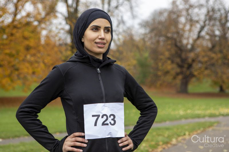 Portrait of woman in black sports clothing and hijab with race number