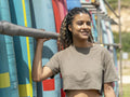 Portrait of smiling woman standing next to paddleboard rack