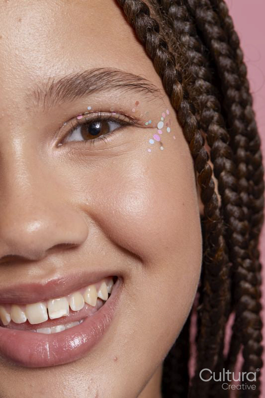 Close-up of smiling girl with decorative stickers on face