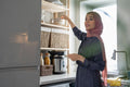 Woman in hijab putting dishes on shelf