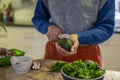 Woman cutting avocado in half at home