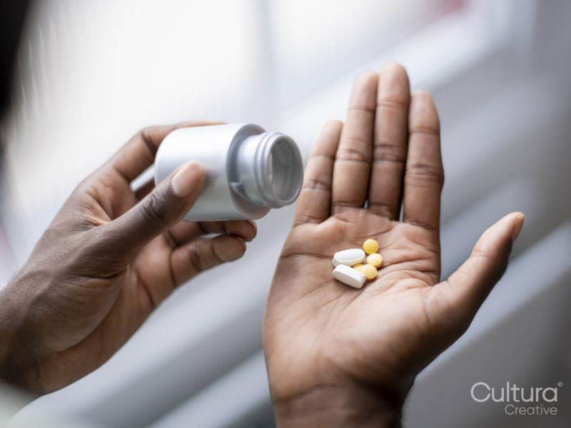 Close-up of person pouring pills on hand