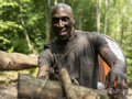 Mature man making fire in forest