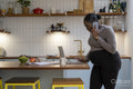Pregnant woman talking on mobile phone in kitchen