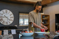 Men with dreads cutting vegetables in kitchen