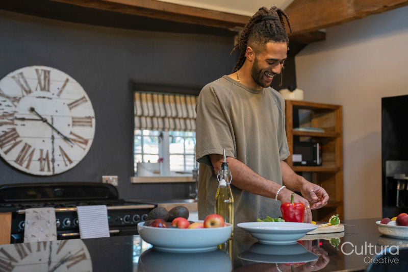 Men with dreads cutting vegetables in kitchen