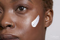 Close-up of woman with face cream on cheek