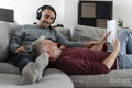 Smiling male couple relaxing on sofa at home