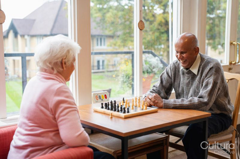 Senior people playing chess in nursing home
