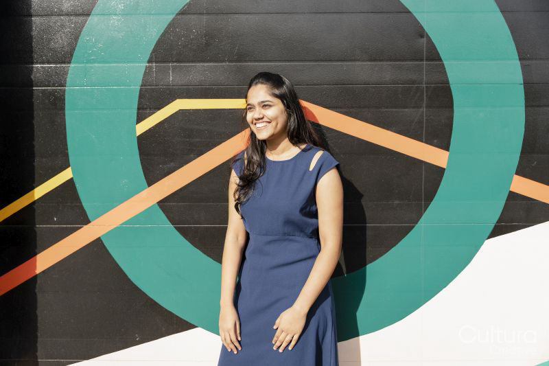 Young woman standing against colorful wall