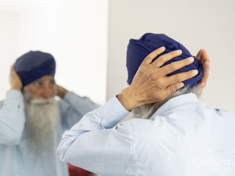 Senior man wrapping turban around head