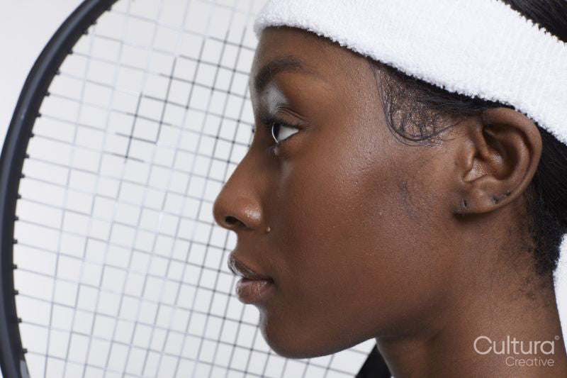 Profile of woman with tennis racket