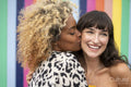 Woman kissing girlfriend on cheek