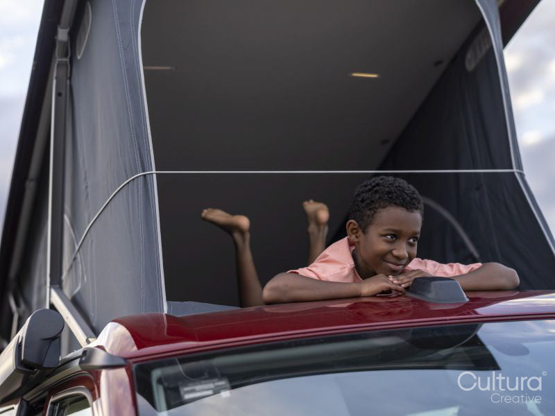 Boy in camper van rooftop tent