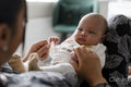 Portrait of newborn baby girl sitting on mother laps