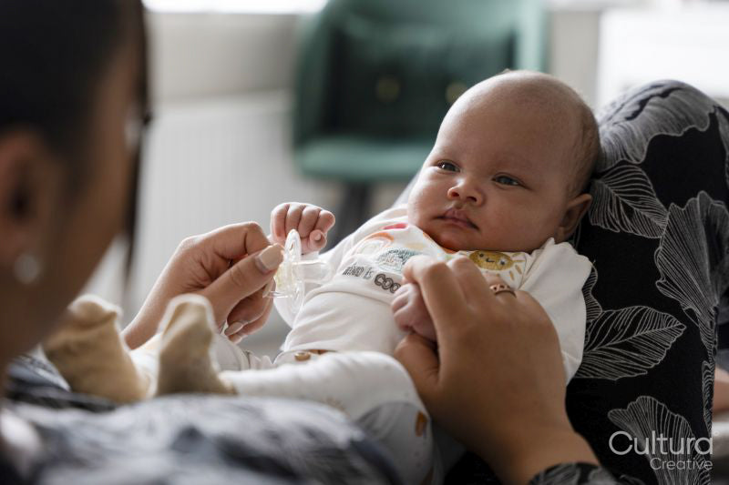 Portrait of newborn baby girl sitting on mother laps