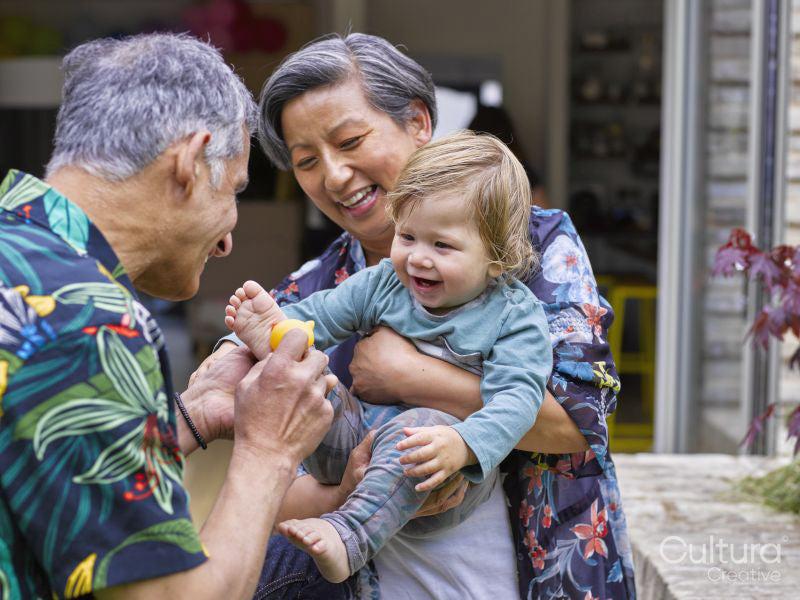 Grandparents playing with grandson outdoors