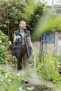 Portrait of woman standing in urban vegetable garden