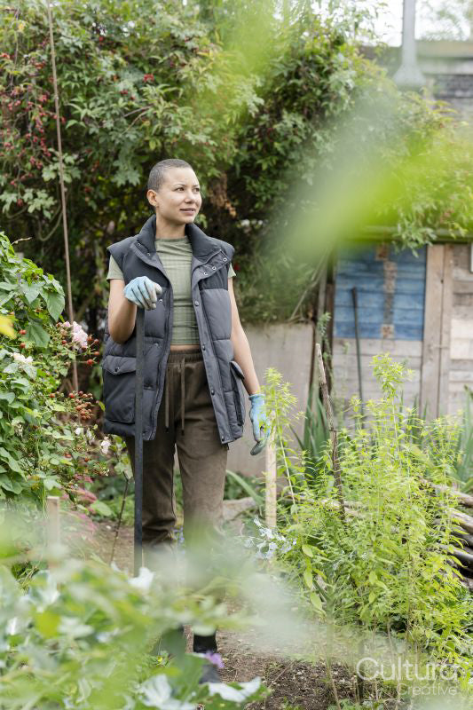 Portrait of woman standing in urban vegetable garden