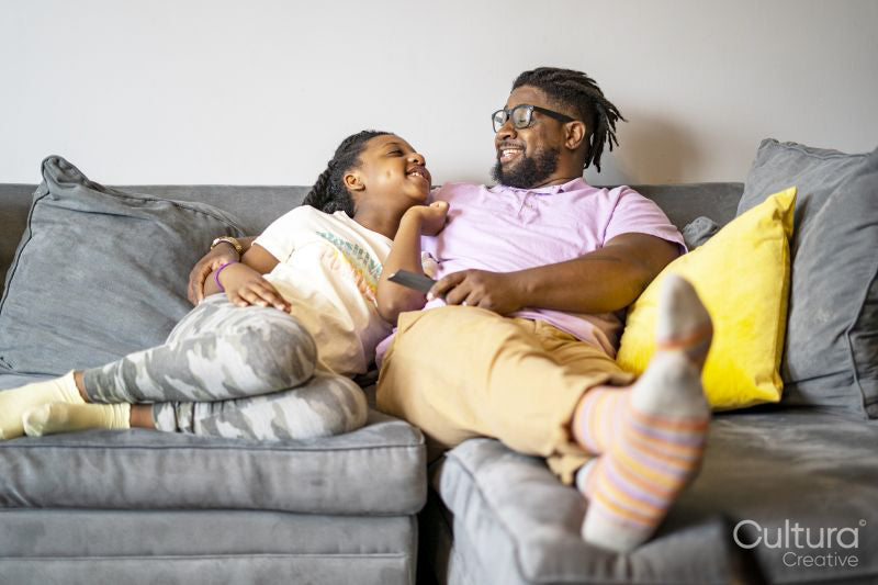 Father and daughter sitting on sofa