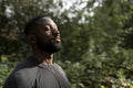 Portrait of athletic man with earbuds standing in park