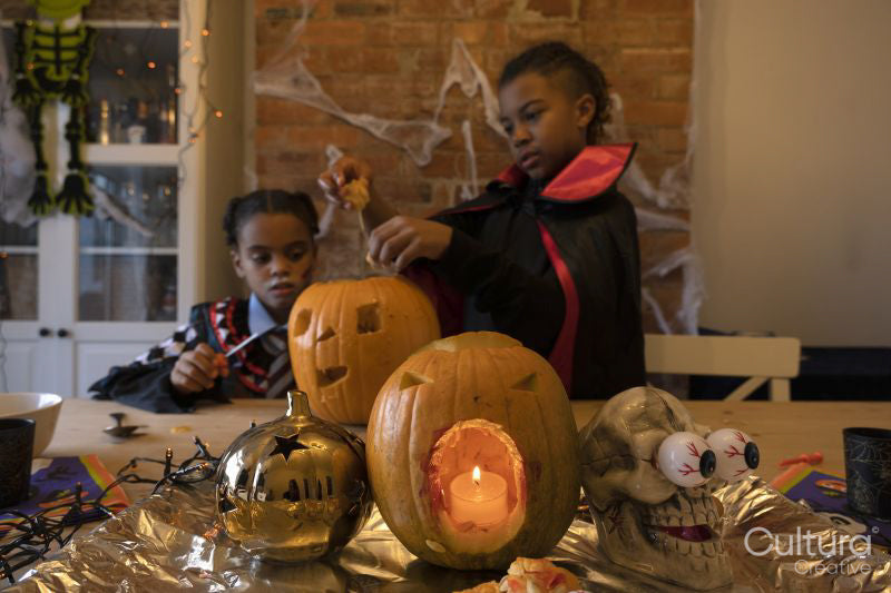 Children in Halloween costumes making Jack O' Lantern