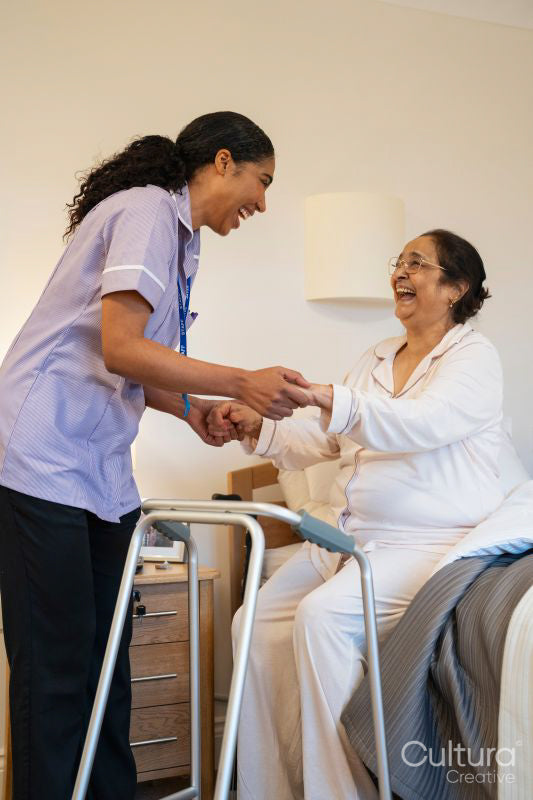Nurse helping senior lady in her room at nursing home