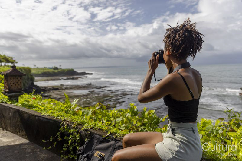 Indonesia, Bali, Female tourist photographing sea from observation point