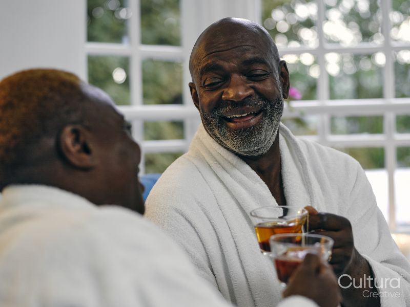 Mature couple in white bathrobes enjoying tea