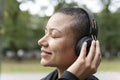 Close-up of smiling woman with headphones in park