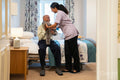 Nurse helping senior man to get dressed at nursing home