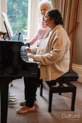 Two senior women at piano in nursing home