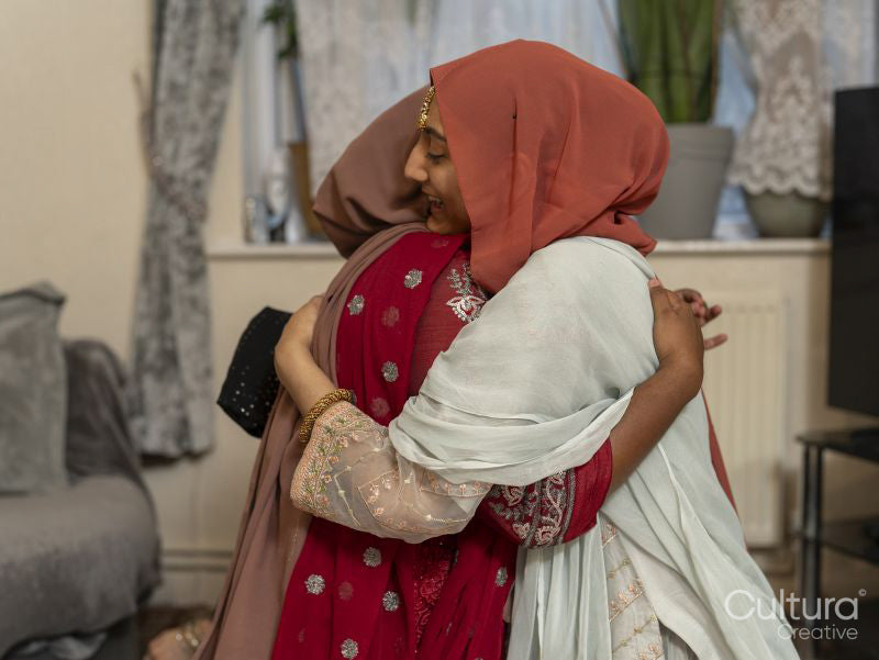 Women hugging during Ramadan celebration at home