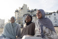 Three Muslim friends sitting on beach