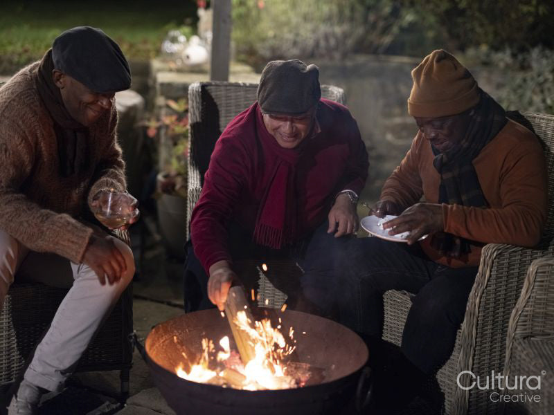 Male friends relaxing by fire pit