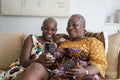 Smiling woman with mother having video call on smart phone at home