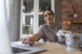 Smiling mother holding baby girl while studying at home
