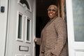 Mature woman standing at front door