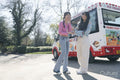 Young women standing next to ice cream truck in park