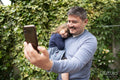 Smiling man taking selfie with daughter outdoors