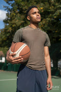 Portrait of pensive man with basketball ball in basketball court