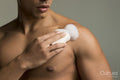 Close-up of man applying soap on chest