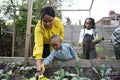 Grandmother with children planting seedlings in garden