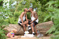 Louisiana, couple with dogs kissing on log in forest