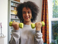 Woman lifting dumbbells at home