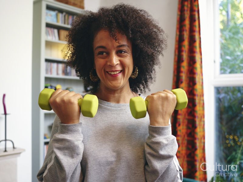 Woman lifting dumbbells at home