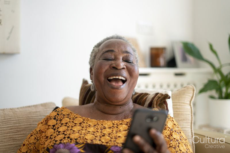 Senior woman holding smart phone and laughing