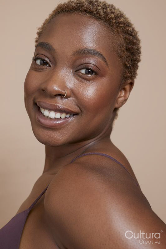 Studio portrait of smiling woman with nose ring