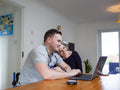 Smiling couple online shopping at home