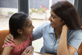 Smiling mother embracing daughter at home